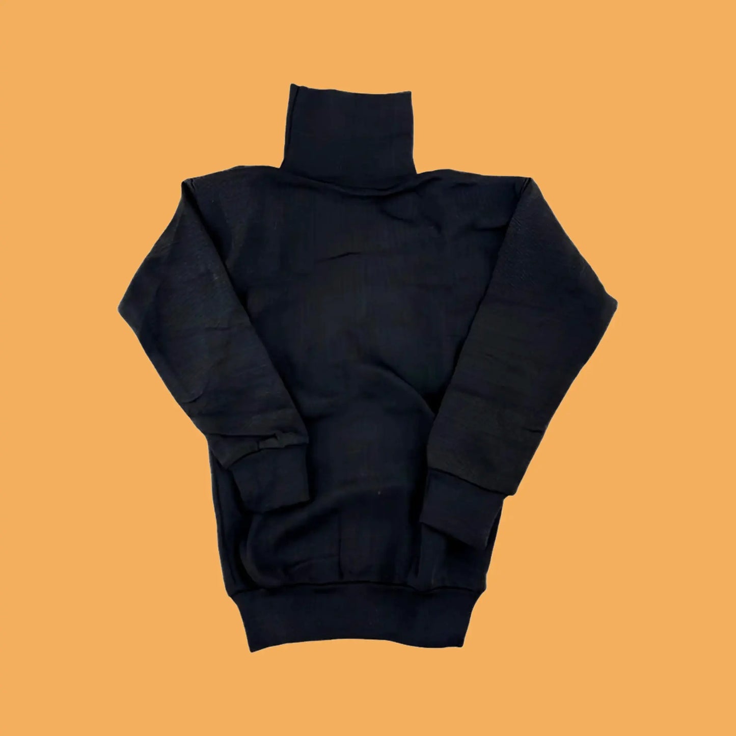 Black turtleneck sweater on a mustard yellow background