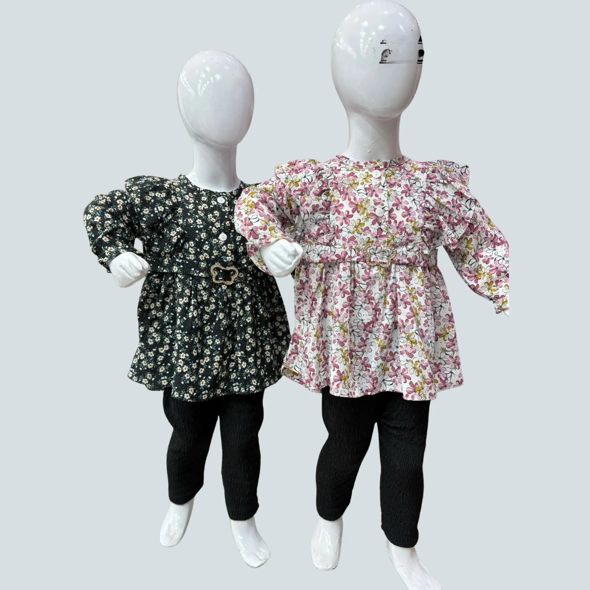 Two mannequins wearing floral tops and black pants on a light gray background