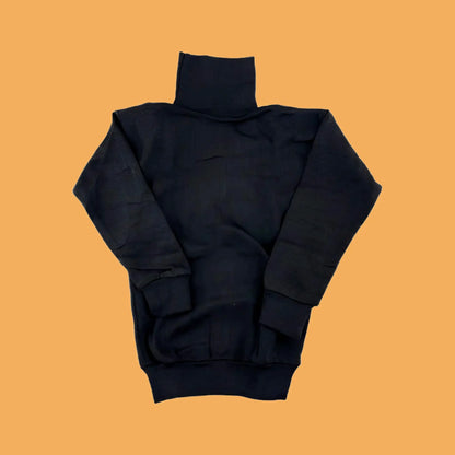 Black turtleneck sweater on a mustard yellow background