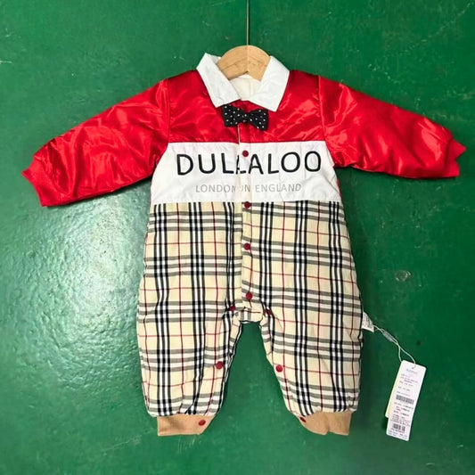Baby romper with red jacket and plaid pants on a green background, featuring the brand 'Dullaloo'.
