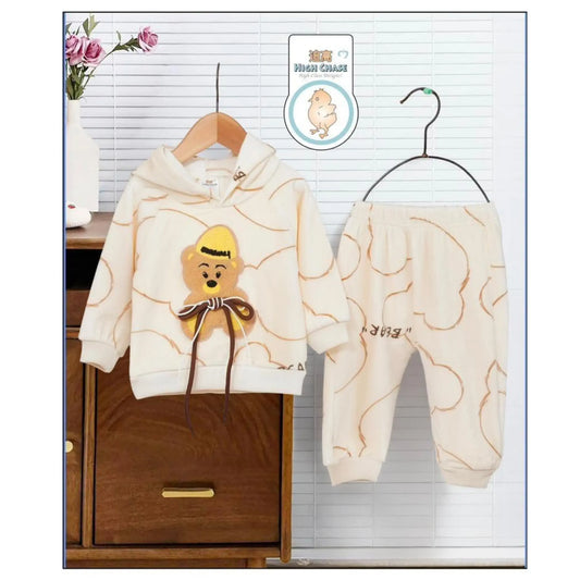 Children's hoodie and pants set with teddy bear design on hangers against a window background.